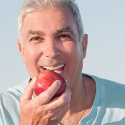 Mature man eating an apple
